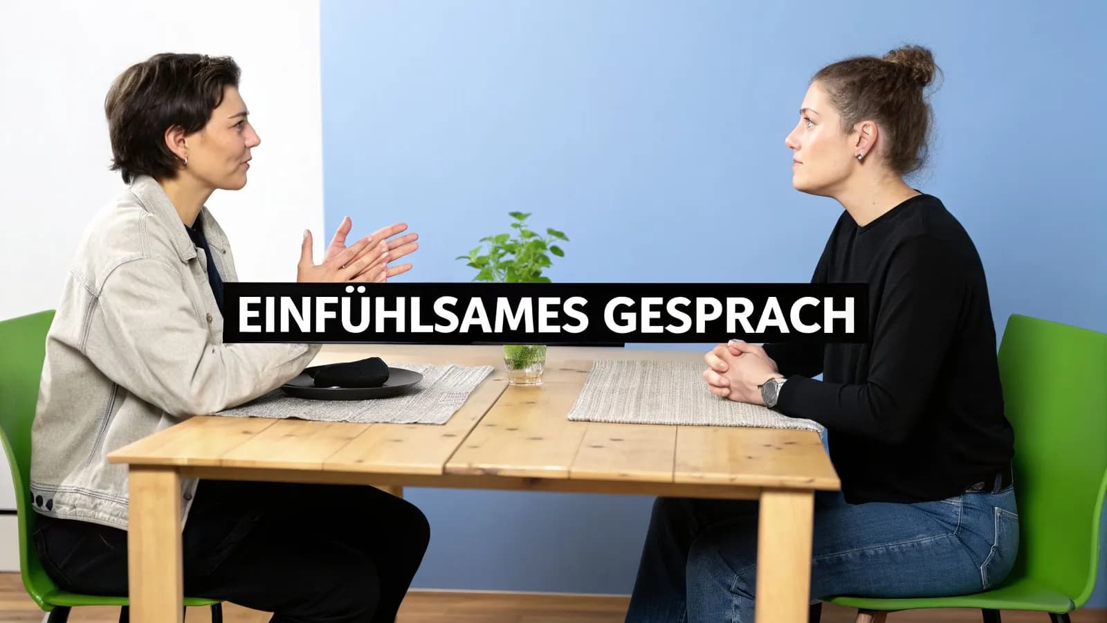 Zwei Personen sitzen sich an einem Tisch gegenüber und führen ein einfühlsames Gespräch.