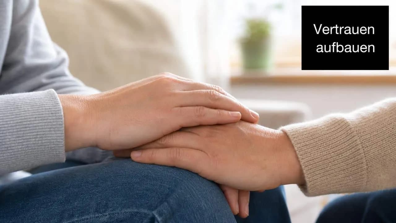 Zwei Hände halten sich tröstend, um Vertrauen in einer psychologischen oder pflegerischen Beratungssituation aufzubauen.